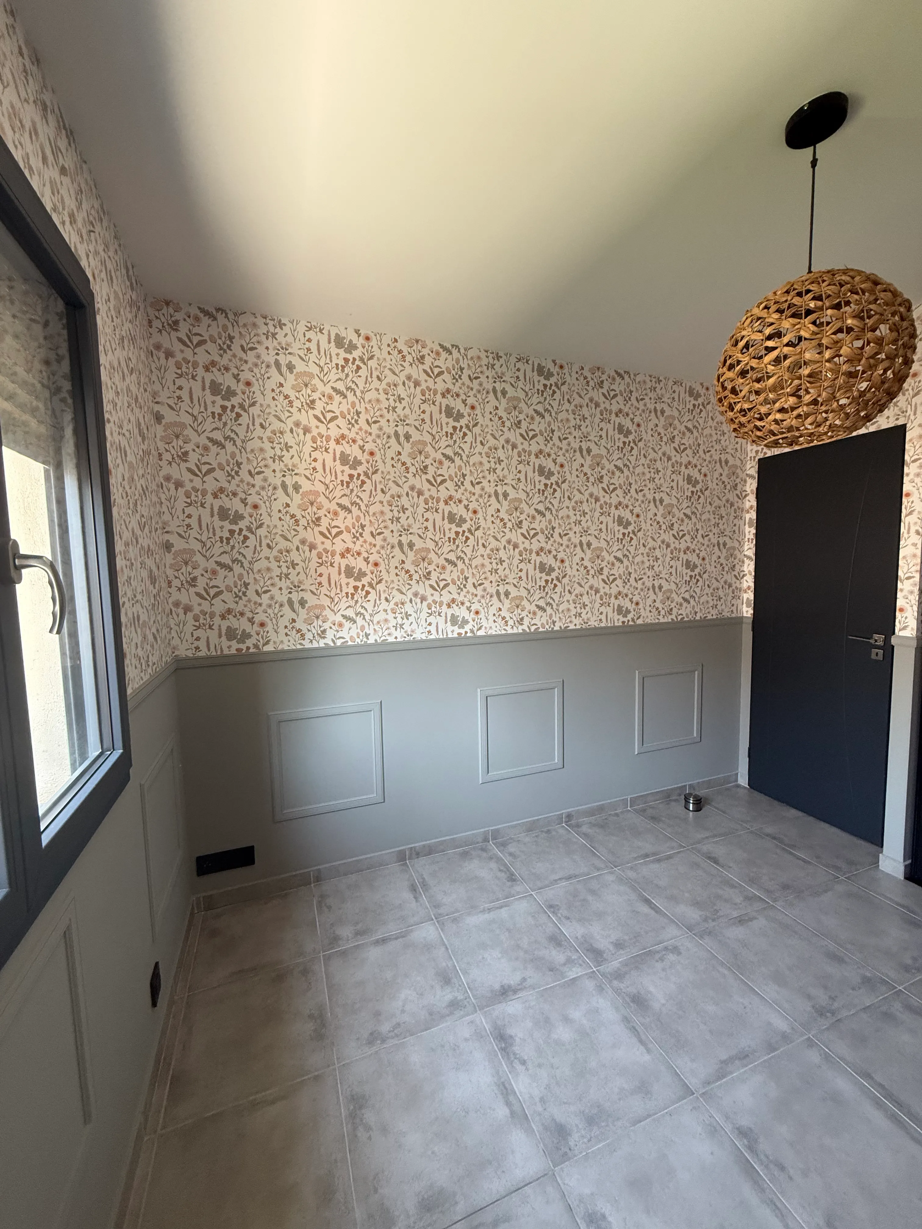 Pièce rénovée avec papier peint fleuri en partie haute et soubassement lambris peint gris — LK Peinture