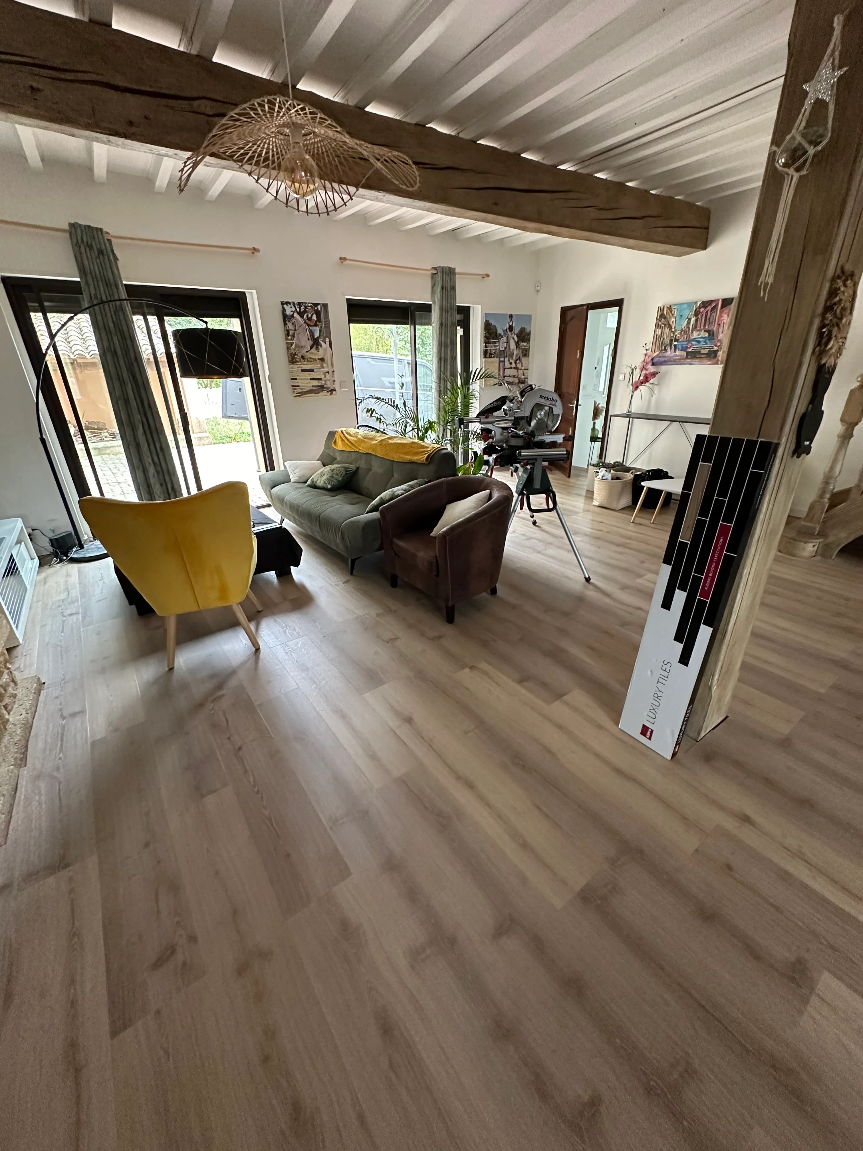 Sol en lames PVC clairs fraîchement posés dans une pièce de vie — réalisation LK Peinture secteur Bram